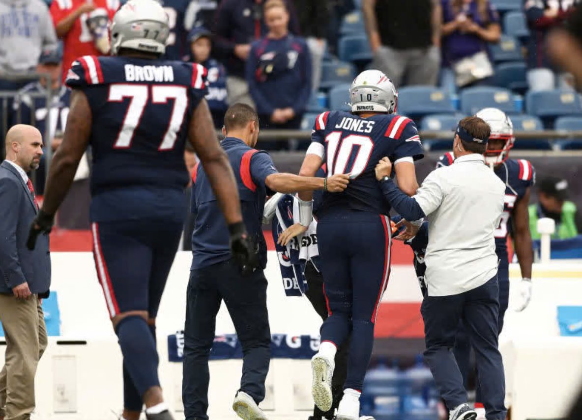 Dr. Nascimento helping a New England Patriots player off the field